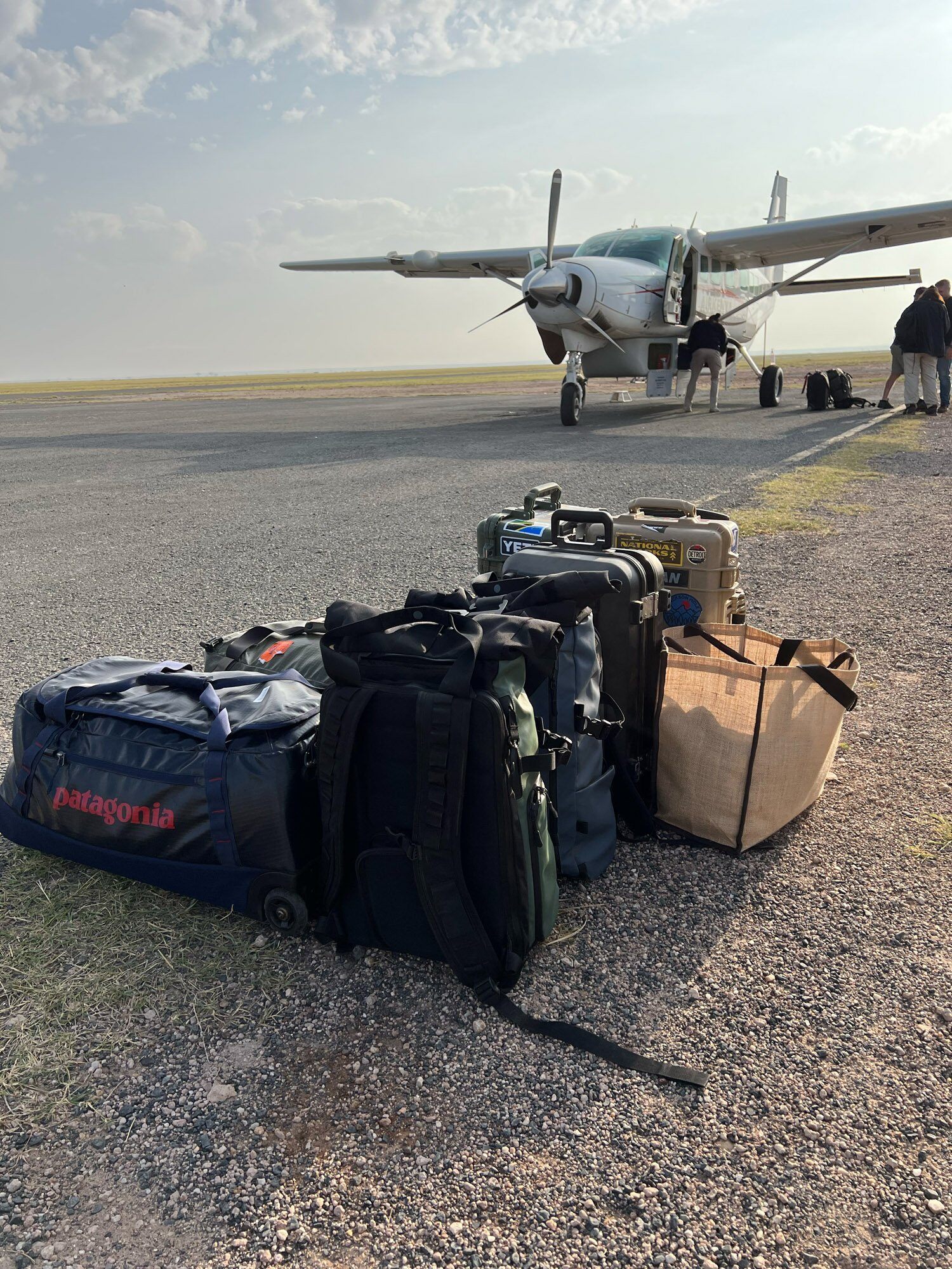 Patagonia, Pelican case and luggage on tarmac with light aircraft ready for takeoff to Serengeti National Park